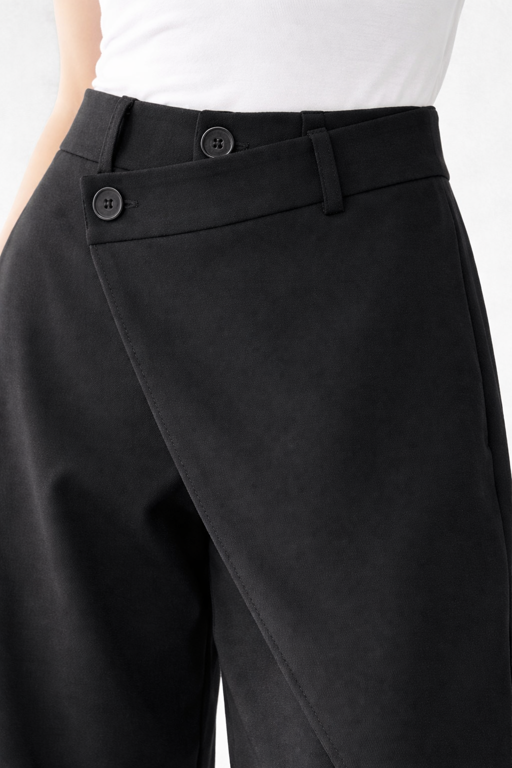 Asymetryczne spodnie z szerokimi nogawkami i ozdobnymi guzikami